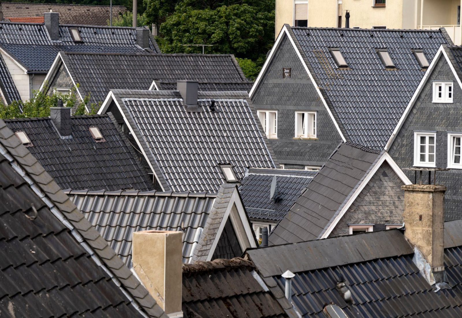 Dichte Schieferdächer mit Gauben und Schornsteinen über einer Stadt