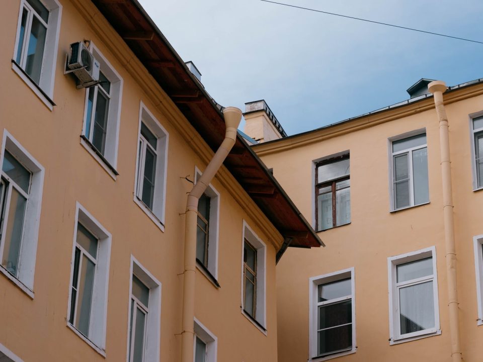 Fallrohr an einer Hausfassade vor blauem Himmel